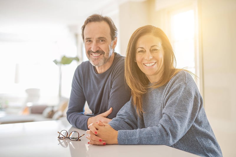 Parents lean against the kitchen counter 