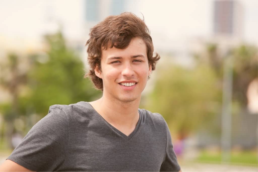 Teen male stands in front of a city skyline