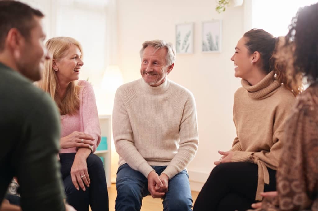 Group of parents sit in a circle during a support group meeting