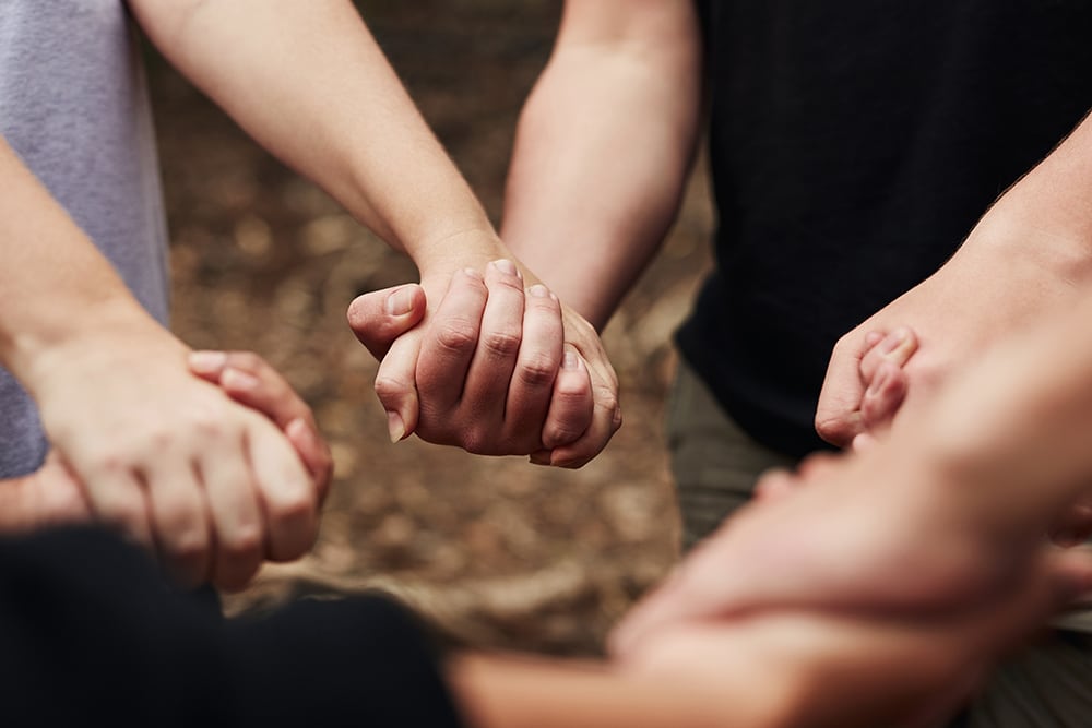 Teens holding hands during wilderness adventure